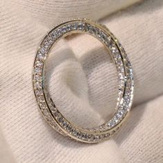 a close up of a ring on a white cloth with diamonds in the middle and inside