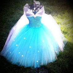 a blue and white dress on display in the grass