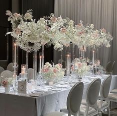 a long table with white and pink flowers in tall vases