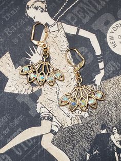 Textured Front, Hollow Back These dainty 1920s inspired earrings feature fan shaped brass pendants with Clear Aurora Borealis Swarovski crystals.   There are shades of blues, pinks, yellows in the clear crystals as they move in the light.  The brass pendants are hollow on the back. (SEE PHOTO) The unique fan shape reminds me of delicate peacock feathers. And speaking of feathers, these dainty earrings are as light as a feather; very lobe-friendly yet sturdy. The earrings measure 1 1/2 inches long and 1 inch wide. They hang from gold plated lever back ear wires. Perfect choice for a 1920s themed wedding or party. ABOUT THIS COLLECTION The sophisticated style of the Roaring Twenties is timeless. The sparkling crystal and luminous pearl jewels in this collection are perfect for your 1920s ins Gold Gatsby Style Party Jewelry, Victorian Dangle Earrings For Party, Victorian Earrings For Pierced Ears For Party, Victorian Style Earrings For Party, Gold Art Nouveau Earrings For Weddings, Gatsby Style Gold Evening Jewelry, Art Nouveau Gold Earrings For Wedding, Art Nouveau Gold Wedding Earrings, Evening Gatsby Gold Jewelry