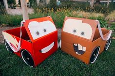 two cardboard cars are sitting in the grass