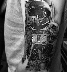 a man's arm with an astronaut tattoo on it