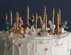 a white cake topped with lots of figurines on top of it's icing