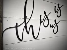 the word thomas written in cursive black ink on a white painted wood wall