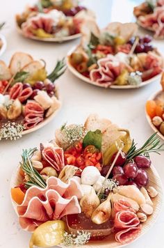 several plates filled with different types of food on top of a white tablecloth covered table