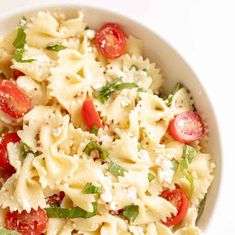 a white bowl filled with pasta and tomatoes