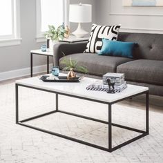 a living room with a couch, coffee table and two lamps on the side tables