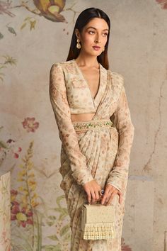 Achieve an elegant and sophisticated look with this ivory printed chiffon full sleeves blouse, paired harmoniously with a chiffon regular sari and a petticoat. The heavy embroidered belt adds a tou... Long Sleeve Blouse Designs, Print Blouse Design, Full Sleeves Blouse, Full Sleeves Blouse Designs, Floral Print Saree, Full Sleeves Design, Ridhi Mehra, Saree Blouse Styles