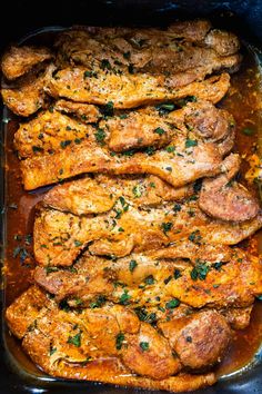 meat in a casserole dish with sauce and parsley