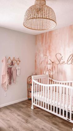 a baby's room with pink walls and wooden floors