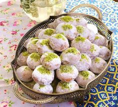 a bowl filled with powdered sugar and green sprinkles on top of a table