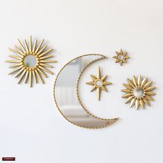 three sun and moon wall hangings on a white wall next to a glass plate