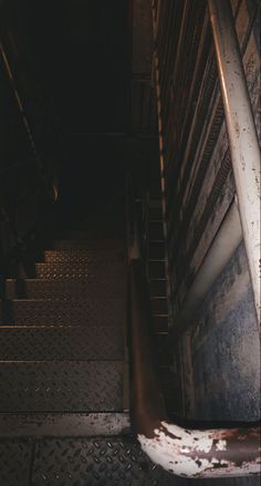 an image of stairs going up to the top floor with rusted steps and railings