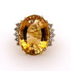 A Magnificent Natural Oval Citrine Quartz Cocktail Ring (size 6).  Set in 14k Yellow Gold, the centerstone measures APPROXIMATELY 18.50x14x10.5mm and weighs APPROXIMATELY16.50 Carats. Set beside the Oval are ten colorless natural round brilliant diamonds weighing 0.43 carats.  The ring weighs 8.67 grams. Estate Oval Ring Stamped 14k, Estate Style Formal Rings With Gemstones, Estate Style Oval Yellow Gold Rings, Yellow Gold Oval Estate Rings, Oval Yellow Gold Estate Rings, Estate Style Gemstone Rings For Anniversary, Classic Multi-stone Oval Topaz Ring, Classic Oval Multi-stone Topaz Ring, Classic Oval Topaz Multi-stone Ring