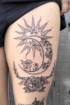 a woman's thigh with tattoos on her legs and the moon in the middle