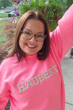 a woman in a pink sweatshirt with the word hauber on it's chest