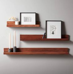 two wooden shelves with candles and pictures on them