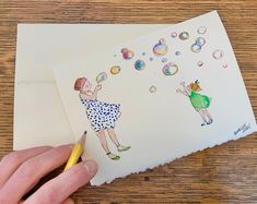 someone is drawing on paper with colored pencils