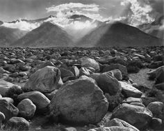 black and white photograph of rocky terrain with mountains in the background