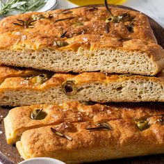 two loaves of bread sitting on top of a wooden cutting board