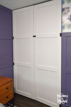 a bedroom with purple walls and white closet doors