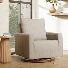 a living room with a chair, table and vase on the floor in front of a window