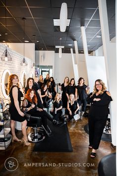 a group of women sitting in front of a hair salon chair with their arms around each other