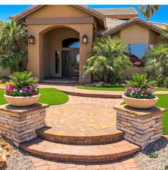 the front entrance to a home with landscaping around it