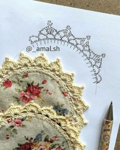 an old doily and crochet pattern next to a pen on top of a piece of paper