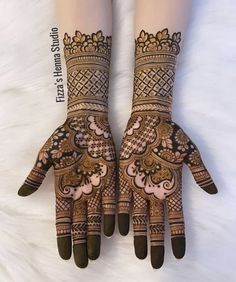 two hands with henna designs on them, one is showing the intricate design and the other has an intricate pattern