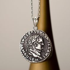 "Titus Flavius Vespasianus Oxidized Silver Reproduction Coin Pendant Head of Titus, laureate. The Inscripotion reads: IMP TITVS CAES VESPASIAN AVG P M for Imperator Titus Caesar Vespasianus Augustus The skillfully oxidized surface on the pendant signifies the longing for the past and symbolizes a journey into the depths of history. This piece combines the elegant brilliance of silver and the charm that time bestows to create a distinctive balance between the modern and the ancient. The physically deformed and oxidized surface blends the charm of antiquity with a modern twist. The surface of the pendant is oxidized and lightly polished. The coin is about 0,75\". Unchained weight is 1.7 grams. With chain average is 3 grams. The chain is 14k gold plated. The pendant is oxidized silver. The ch Silver Byzantine Jewelry With Coin Pendant, Etruscan Jewelry Silver Pendant, Silver Byzantine Coin Necklace, Engraved Coin-shaped Amulet Jewelry, Ancient Coin Pendant, Rome Antique, Necklace Antique, Coin Pendant, Oxidized Silver