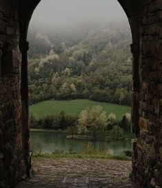 an archway leading into a lush green valley