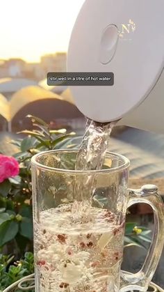 a pitcher pouring water into a glass mug