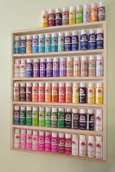 a wooden shelf filled with lots of different types of paint