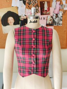 a mannequin wearing a pink and black plaid shirt with buttons on the front