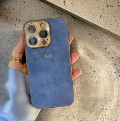 a person holding an iphone case in their hand with the initials on it and gold hardware