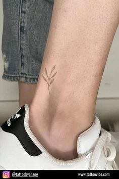 a woman's foot with a small plant tattoo on her left side calfocks