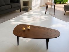 a coffee table sitting on top of a white tile floor next to a couch and chair