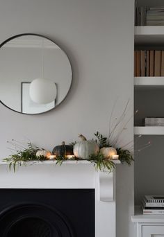 a living room with a fire place and a mirror on the wall above it's mantle