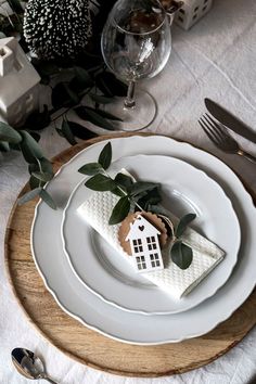 a white plate topped with a piece of cake on top of a wooden tray next to silverware