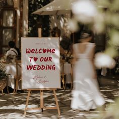 a welcome to our wedding sign on an easel in the middle of a courtyard