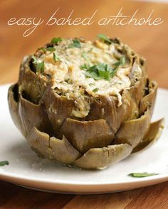 an artichoke on a white plate with the words easy baked artichoke