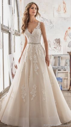 a woman standing in front of a window wearing a wedding dress