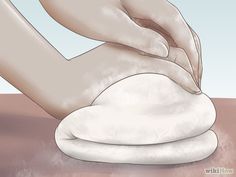 a person is kneading dough on top of a round object with their hands