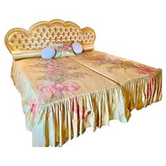 a bed with an elaborate headboard and foot board on it's sides, made out of gold fabric