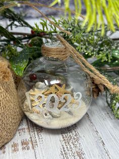 a glass ornament filled with sand and starfish on top of a table