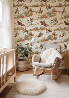 a baby's room with a rocking chair and horse wallpaper