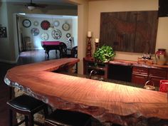 a large wooden counter top sitting inside of a kitchen next to a dining room table