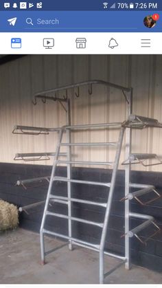 a metal ladder is in front of a wall with several hooks on it and hay