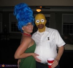 a man and woman dressed up as simpsons and the simpsons is posing for a photo